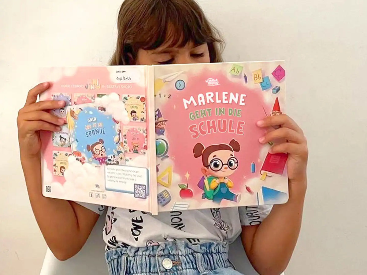 Ein Mädchen liest ihr personalisiertes Buch zum ersten Schultag.  