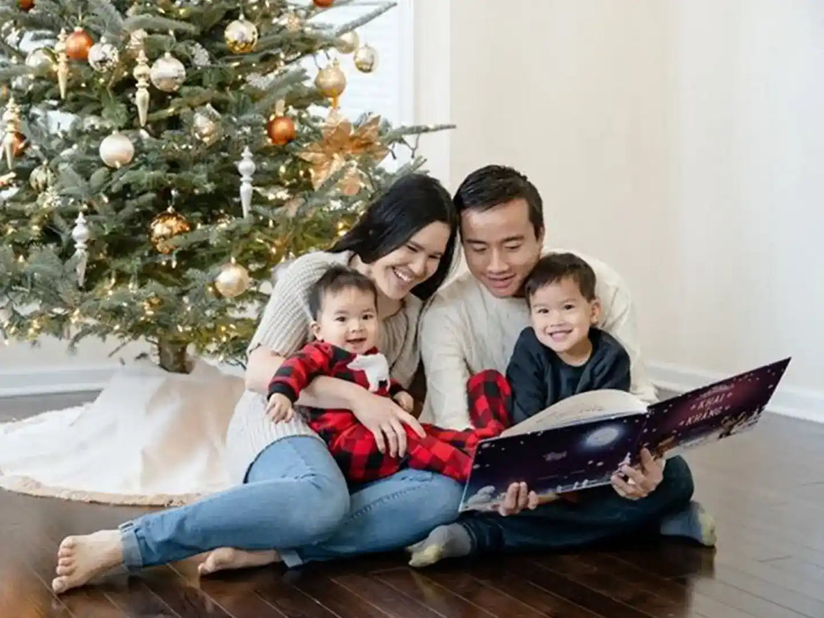 Eine Familie feiert Weihnachten und liest das personalisierte Buch für zwei Kinder von Hurra Helden. 
