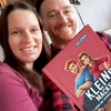 Ein Paar kuschelt glücklich mit einem lustigen Buch über die Unvollkommenheiten der besseren Hälfte.