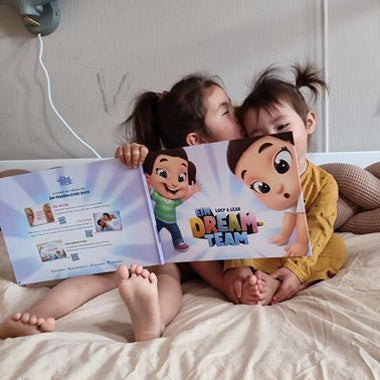 Zwei Kinder blättern in ihrem personalisierten Buch für Kinder „Ein Dreamteam“ von Hurra Helden.