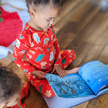Ein Mädchen blättert in ihrem eigenen personalisierten Weihnachtsbuch, in dem sie ebenfalls die Hauptrolle spielt.