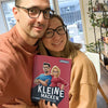 Ein Mann und eine Frau halten ihr wunderbar lustiges Buch über ihre perfekten Unvollkommenheiten in der Hand.