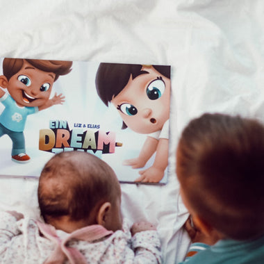 Zwei Kinder lesen das personalisierte Buch für Geschwister „Ein Dreamteam“ von Hurra Helden.