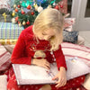 Ein Mädchen blättert in seinem personalisierten Buch über Weihnachten von Hurra Helden, das voller magischer Geschichten ist.
