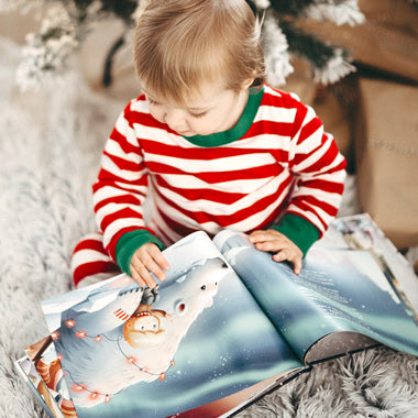 Ein Kind blättert in seinem personalisierten Buch über Weihnachten von Hurra Helden, das voller magischer Geschichten ist.