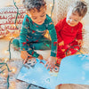 Zwei Kinder blättern in ihrem eigenen personalisierten Buch, das über Weihnachten und ihrer Verbindung handelt.
