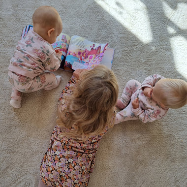 Drei Kinder bewundern ihr neues personalisiertes Kinderbuch „Ein Dreamteam“, das von fantasievollen Geschichten handelt.