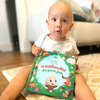 Ein kleiner Junge mit seinem personalisierten Buch zu Weihnachten von Hurra Helden. 