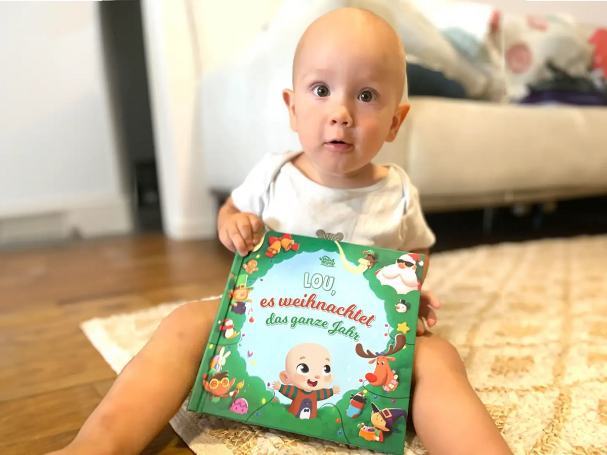 Ein kleiner Junge mit seinem personalisierten Buch zu Weihnachten von Hurra Helden. 
