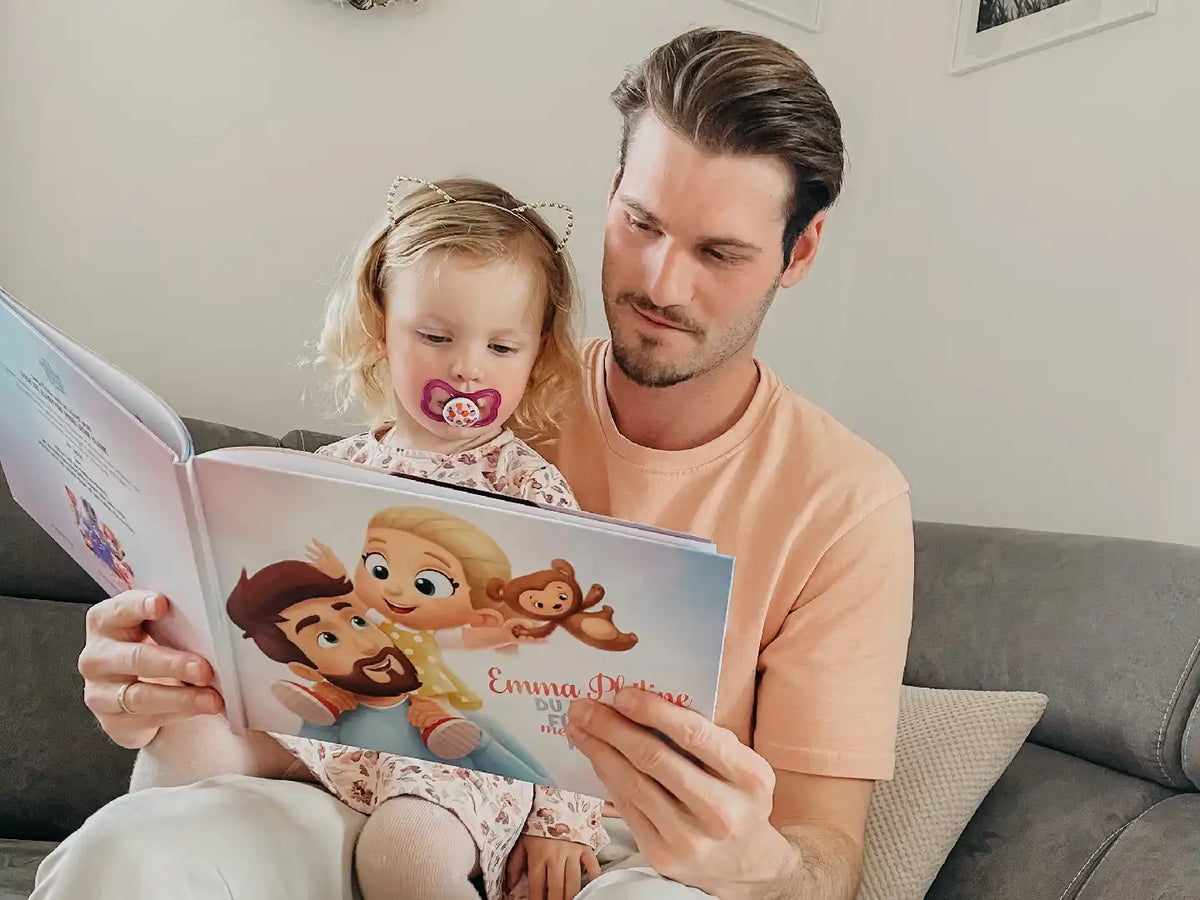 Ein Mädchen sieht sich ein Buch an, das für ihren Vater und sie von Hurra Helden angefertigt wurde.