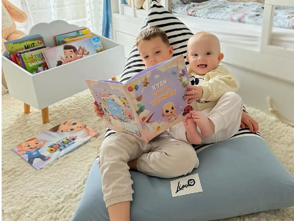Süße Kinder posieren neben ihrem personalisierten Babybuch, das ein tolles Geschenk für neue Familien ist.	