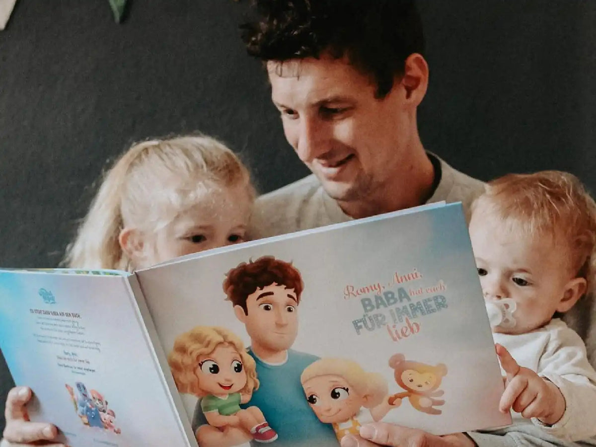 Ein Vater liest mit seinen 2 Töchtern das beste Geschenk für Papas zum Vatertag. 