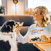 Frau hält ein Buch für ein Kind und sein Haustier mit personalisierten Charakteren.	