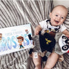 Ein Baby mit seinem personalisierten Buch für Papas und Kind von Hurra Helden. 