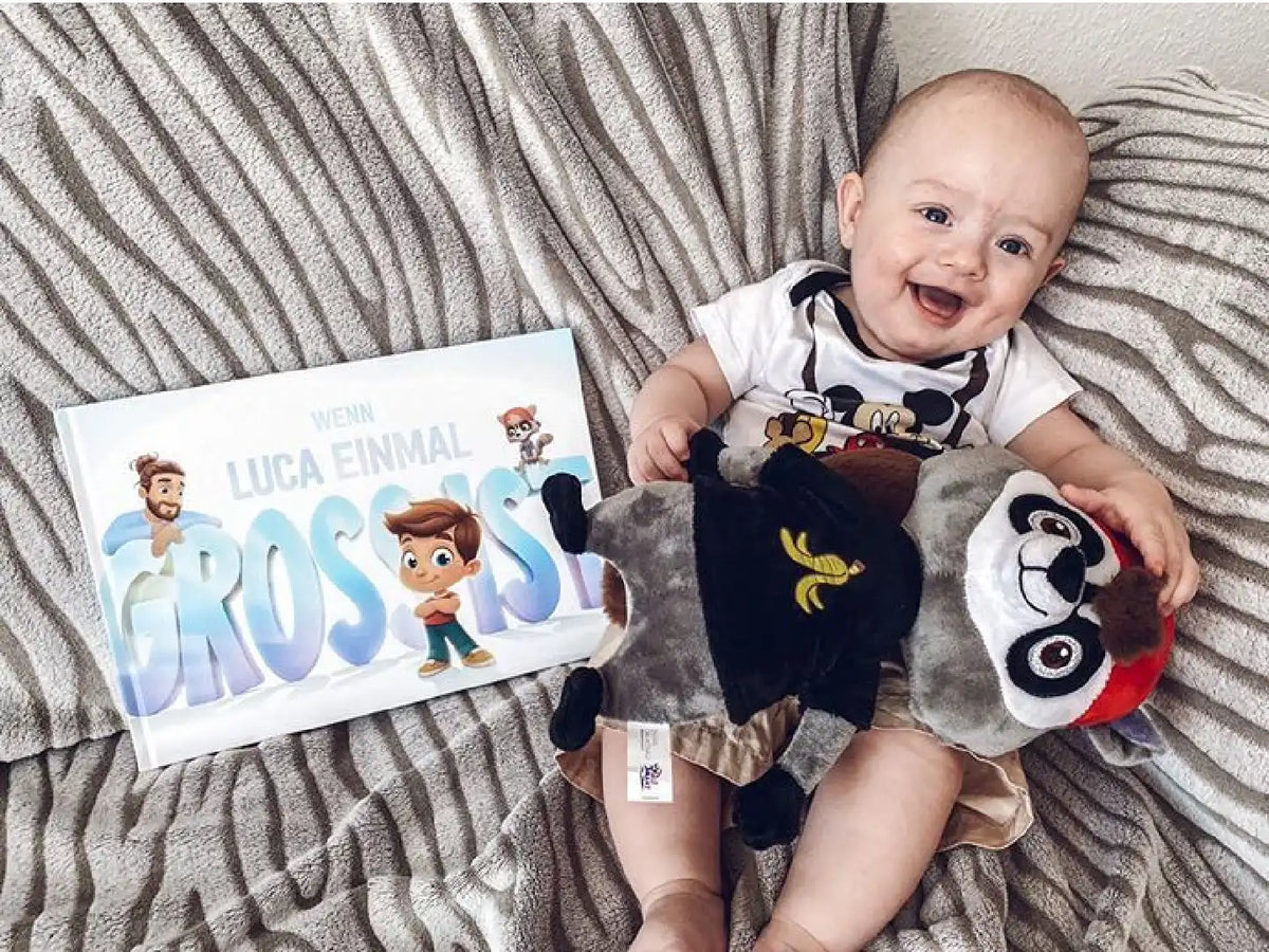 Ein Baby mit seinem personalisierten Buch für Papas und Kind von Hurra Helden. 
