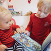 Zwei Brüder blättern in ihrem individuellen Buch für Geschwister zu Weihnachten von Hurra Helden. 