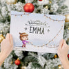 Eine Frau hält ein personalisiertes Weihnachtsbuch in der Hand, das das beste Geschenk für Kinder zu Weihnachten ist.
