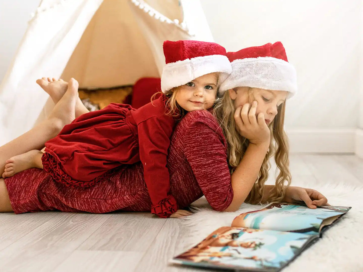 Zwei Mädchen lesen ein personalisiertes Weihnachtsbuch.