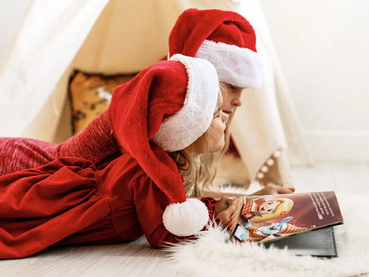 Zwei Mädchen genießen ihr personalisiertes Weihnachtsbuch.