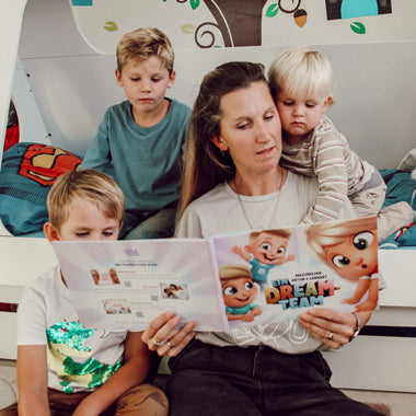 Drei Kinder und ihre Mama bewundern ihr neues personalisiertes Geschwisterbuch, in dem drei Kinder die Hauptrolle spielen.