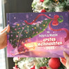 Nahaufnahme des personalisierten Weihnachtsbuchs „Peters & Mamas – Erstes Weihnachten 2025“ vor dem Christbaum.
