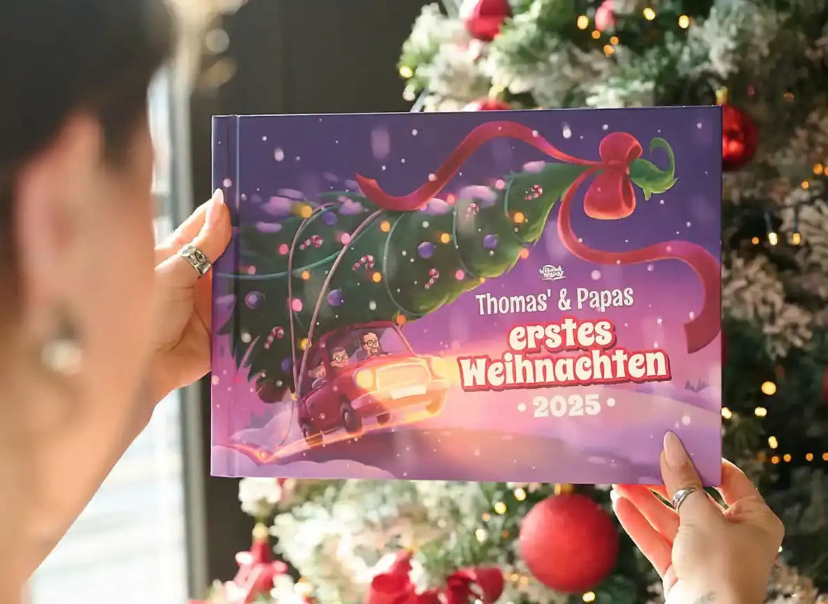 Person hält das personalisierte Weihnachtsbuch „Thomas & Paps – Erstes Weihnachten 2025“ vor einem geschmückten Baum.