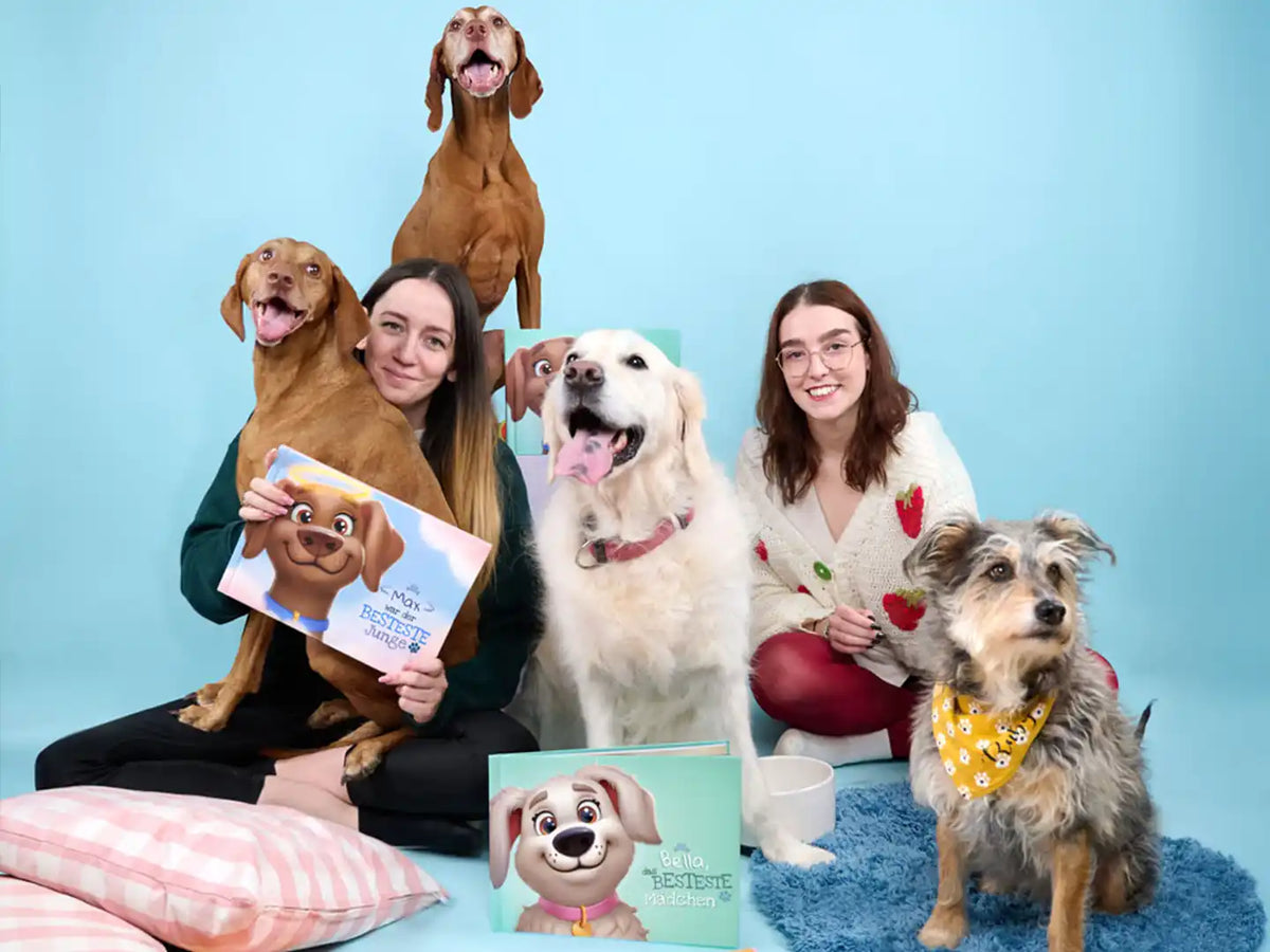 Fröhliche Hundebesitzer mit ihren Hunden und den personalisierten Gedenkbüchern „Max war der BESTESTE Junge“ und „Bella das BESTESTE Mädchen“ – liebevolle Hommage an unvergessliche Fellfreunde.